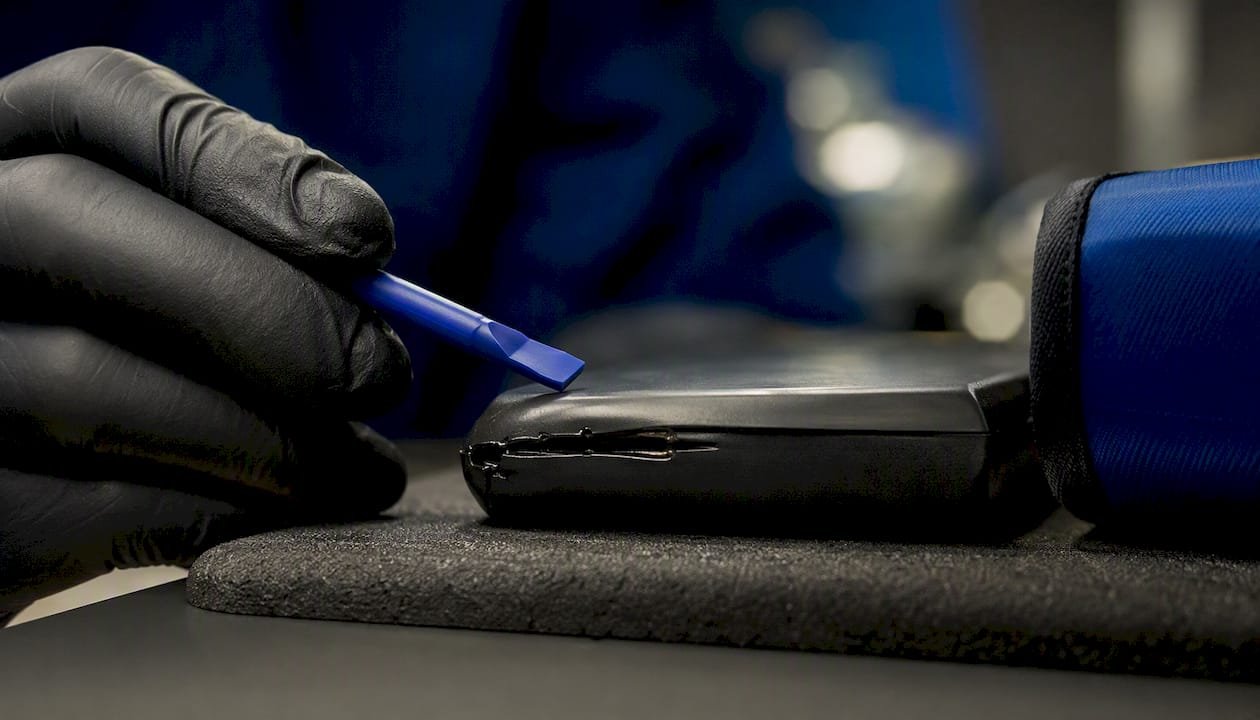 Technician inspecting swollen battery casing